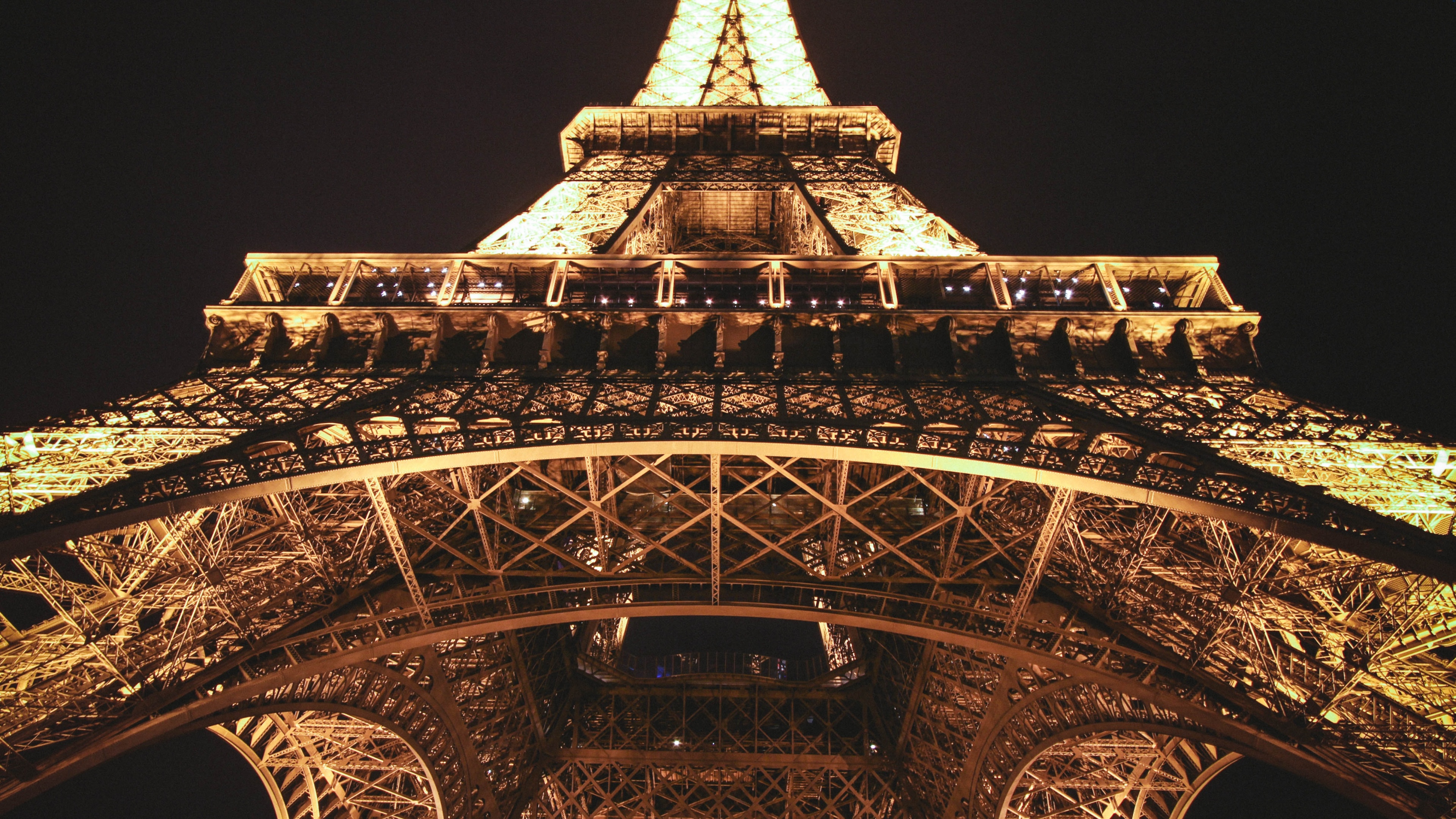 A stunning close-up view of the Eiffel Tower, a renowned landmark in Paris, France. This 4K wallpaper showcases the architectural beauty and charm of the iconic tourist attraction.