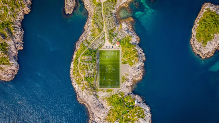 A stunning 4K wallpaper featuring Henningsvaer Stadium during the day. This captivating view showcases the scenic beauty of the stadium, providing a magnificent backdrop for sports enthusiasts and fans alike.