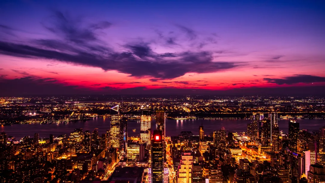 A mesmerizing twilight view of New York City captured in stunning 4K resolution. This captivating wallpaper showcases the urban cityscape with its iconic skyline, creating a picturesque scene of the city at night.