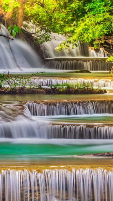 Immerse yourself in the natural beauty of Erawan Falls in Thailand with this captivating 4K wallpaper. The lush forest surroundings and cascading waterfalls create a scenic and tropical paradise that's perfect for travelers and those seeking a desktop background that captures the serene beauty of this stunning Thai destination.