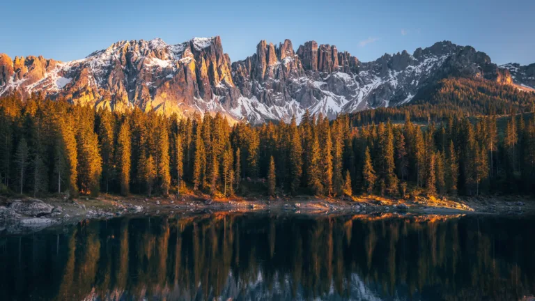 Immerse yourself in the serene beauty of Karersee Lake in Italy's Dolomites with this mesmerizing 4K wallpaper. The alpine lake, surrounded by the stunning landscape of South Tyrol, offers a tranquil and scenic escape. Perfect for travelers and those seeking a desktop background that captures the natural tranquility and alpine wonder of this Italian gem.