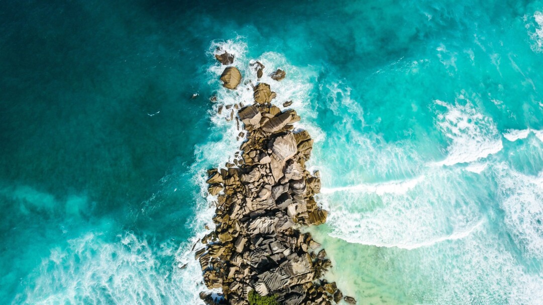 Transport yourself to the pristine beauty of Seychelles Beach with this breathtaking 4K wallpaper. The turquoise waters, palm-fringed coastline, and Indian Ocean backdrop create an exotic tropical paradise. Perfect for travelers and those seeking a serene and scenic desktop background that evokes an island escape.