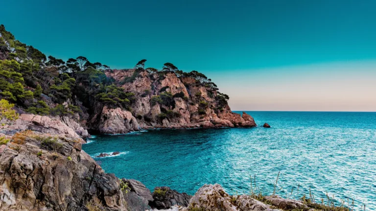Immerse yourself in the beauty of Spain with this stunning 4K wallpaper of a tranquil beach along the Mediterranean coast. Ideal for creating a relaxing atmosphere on your screen or for travel enthusiasts dreaming of a European seaside vacation.