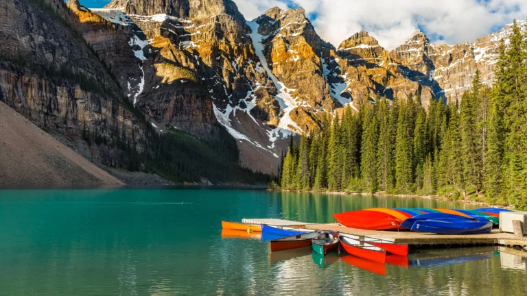 Experience the serene beauty of Moraine Lake in Banff National Park, Canada, with this 4K wallpaper featuring boats on the tranquil turquoise waters. Capturing the picturesque landscape, it showcases the iconic beauty of Moraine Lake in high resolution.