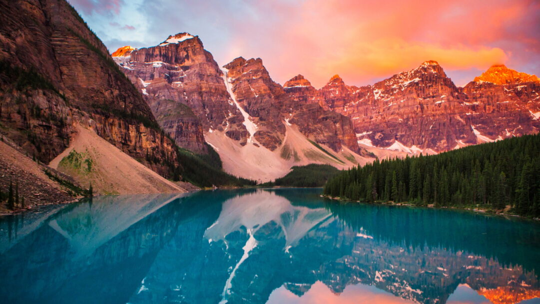 Experience the serene beauty of a captivating sunset at Moraine Lake in Banff National Park, Canada, through this 4K wallpaper. The vibrant hues reflecting on the tranquil waters create a picturesque scene, capturing the essence of this iconic location in high resolution.