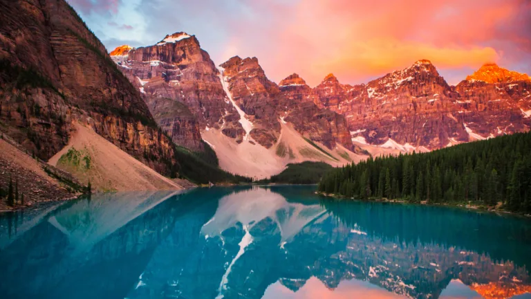 Experience the serene beauty of a captivating sunset at Moraine Lake in Banff National Park, Canada, through this 4K wallpaper. The vibrant hues reflecting on the tranquil waters create a picturesque scene, capturing the essence of this iconic location in high resolution.