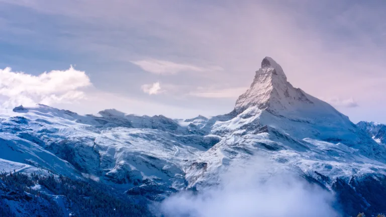 A breathtaking 4K wallpaper featuring the iconic Matterhorn in Switzerland, surrounded by the majestic Alps. The snow-capped peak rises against a stunning alpine landscape, creating a picturesque scene that is perfect for your desktop or mobile wallpaper.