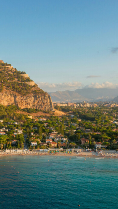 A breathtaking 4K wallpaper presents an aerial view of Mondello Beach, where the azure sea meets the sandy coastline under the Mediterranean sun. The drone-captured image showcases the stunning beauty of this Sicilian destination, making it an irresistible choice for your desktop or mobile wallpaper.