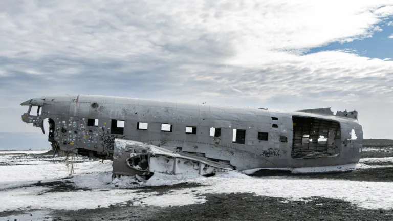 A breathtaking 4K wallpaper captures the Solheimasandur plane wreck amidst a winter landscape. The abandoned airplane lies frozen in time, surrounded by pristine snow and icy terrain, creating a dramatic and atmospheric scene. Perfect for adorning your desktop or mobile screen with a stunning winter vista.