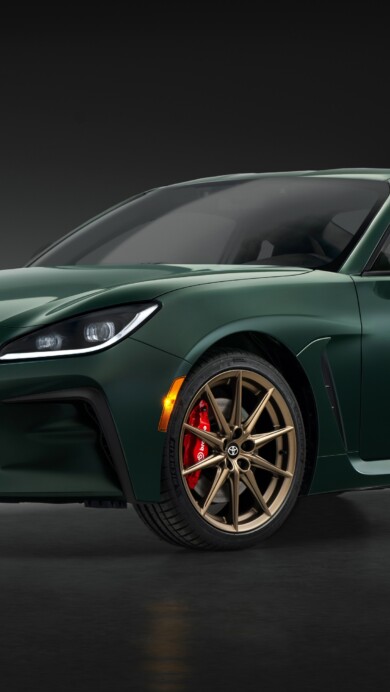 A stunning 4K wallpaper featuring the 2025 Toyota GR86 Hakone Edition. The car is showcased in a dynamic stance, highlighting its sleek design and unique green color, set against a scenic background.