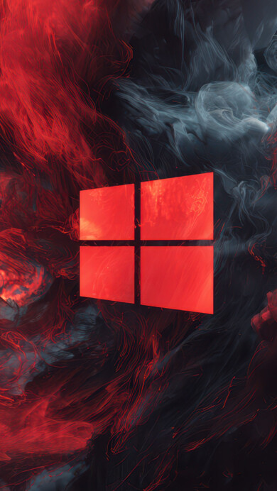 A fiery 4K wallpaper displaying a prominent, glowing red Windows logo centered amidst an abstract explosion of swirling red and dark gray smoke. The vibrant, almost molten red smoke dramatically contrasts with the deep, cool gray, creating an energetic and intense atmospheric mood, enhanced by its fine, filamentous texture.