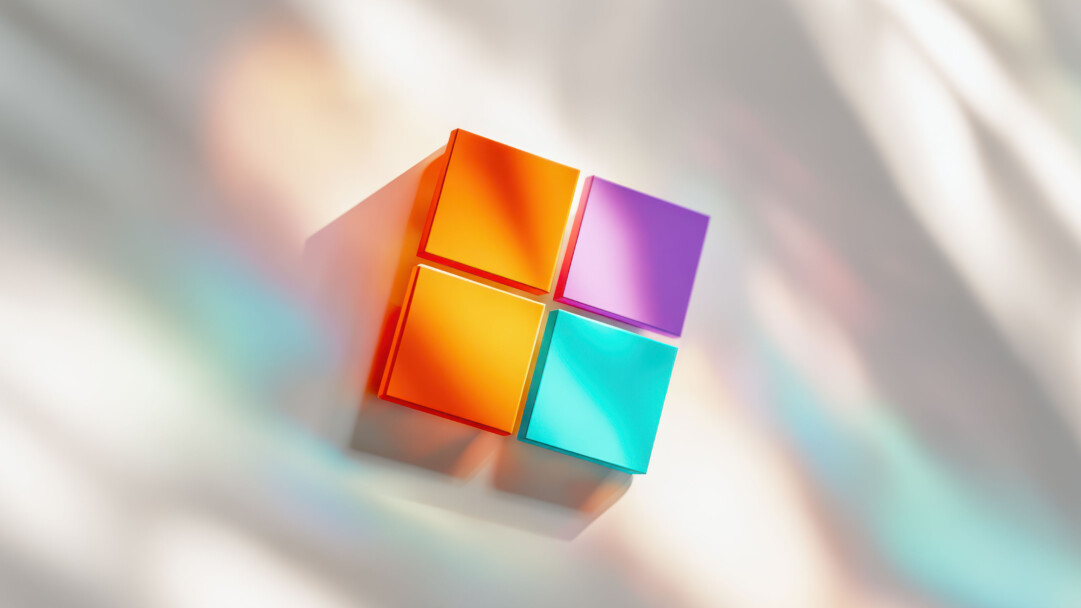 A vibrant 4K wallpaper showcasing a modern, geometric Microsoft Windows logo, composed of four colorful, slightly raised squares against a soft, diffused background. The interplay of vivid orange, purple, yellow, and teal on the logo with the background's ethereal light streaks and prismatic reflections creates a dynamic and futuristic ambiance.
