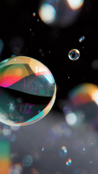 A breathtaking 4K wallpaper featuring numerous vivid, multi-colored bubbles floating within a deep, dark, abstract space. Their surfaces gleam with intense, prismatic colors and soft light reflections, creating a magical and dreamlike atmosphere.