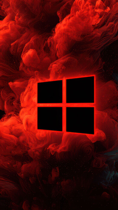 A powerful 4K wallpaper showcasing a bold, glowing red Windows logo at its center, enveloped by swirling, vibrant red and subtle dark teal smoke against a pitch-black background. The fiery red smoke billows outwards with a mesmerizing, ethereal texture, making the red-outlined icon appear to emerge from a passionate, chaotic energy.