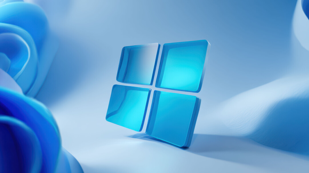 An ethereal 4K wallpaper showcases the Windows 11 logo, rendered as four luminous, translucent blue squares, gracefully floating above a subtly undulating, abstract blue surface. Soft light illuminates the logo, particularly brightening its top-left pane, while gentle shadows and fluid background shapes create a serene and modern aesthetic.