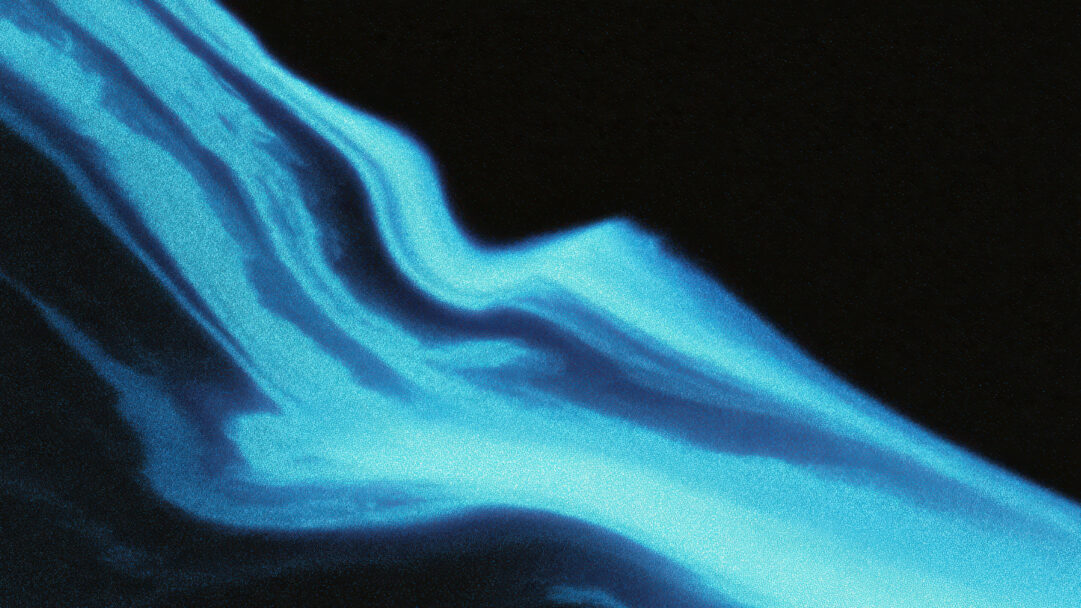 A captivating 4K wallpaper depicts shimmering, abstract blue waves flowing diagonally across a deep dark background. The vibrant blue forms shimmer with a fine, granular texture, creating an ethereal glow that evokes a sense of fluid motion and depth against the dark expanse.