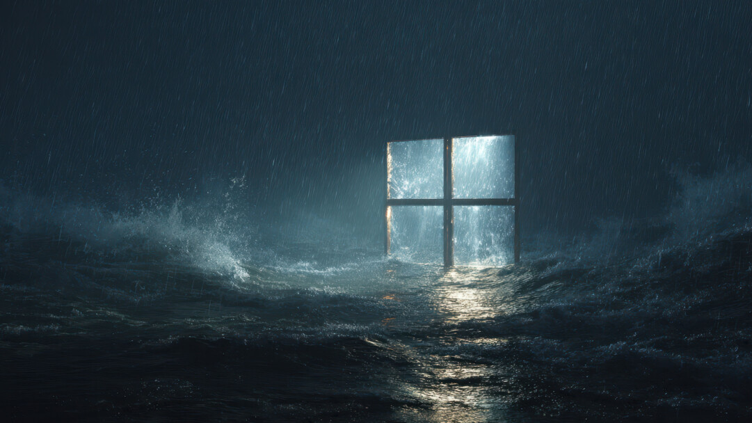 An immersive 4K wallpaper showcases a luminous Windows logo standing resiliently amidst a powerful, dark ocean during a raging storm. Brilliant light from the logo pierces the torrential rain and reflects across the churning, dark waves, creating a dramatic interplay that emphasizes the storm's raw power.