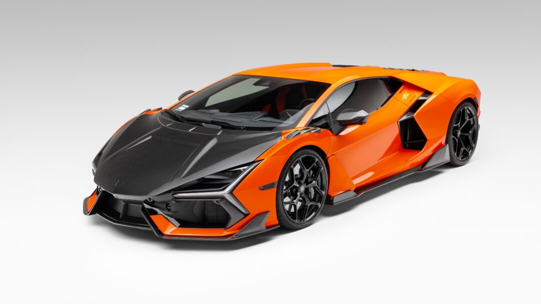An electrifying 4K wallpaper showcases an orange Lamborghini Revuelto parked dramatically on a bright, minimalist studio backdrop. Its vibrant orange body is boldly contrasted by extensive dark carbon fiber detailing on the hood and aerodynamic elements, highlighting its cutting-edge design and powerful presence.