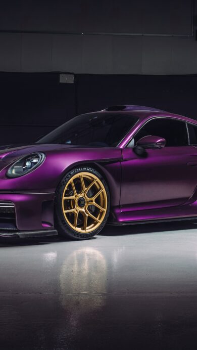 A breathtaking 4K wallpaper showcases a custom Porsche 911 Turbo S positioned in a dimly lit, minimalist studio environment. Its distinctive matte purple paintwork, perfectly complemented by the gleaming gold multi-spoke wheels, creates a luxurious and powerful visual contrast.