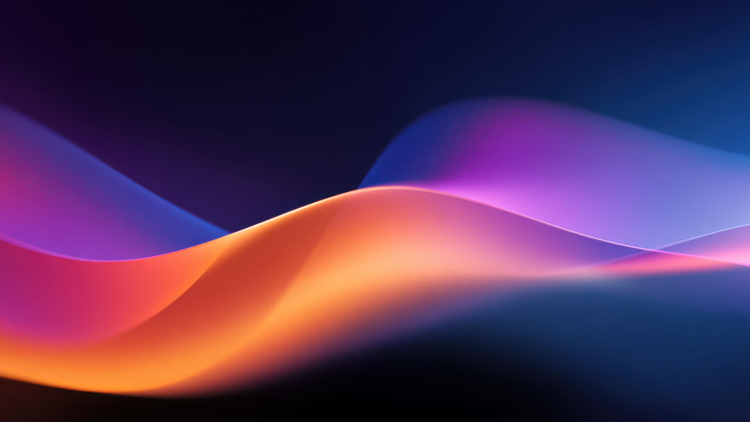 A vibrant 4K wallpaper presents gentle, abstract flowing color waves that undulate smoothly across a shadowy expanse, creating a serene visual for a Windows 11 interface. The luminous edges where warm oranges meet cool purples and blues highlight the sculptural forms and evoke a tranquil yet dynamic mood.