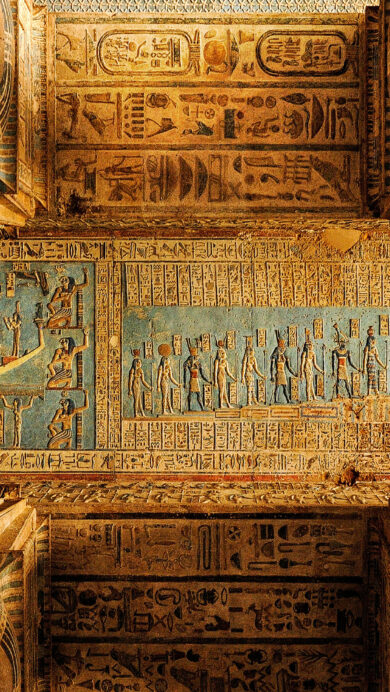 A magnificent 4K wallpaper captures the ornate ceiling of the Temple of Hathor in Dendera, Egypt, adorned with countless ancient hieroglyphs. Detailed carvings depict mythological scenes and deities in faded blues and golds, beautifully framed by massive, intricately decorated columns that ascend towards the ancient narrative above.