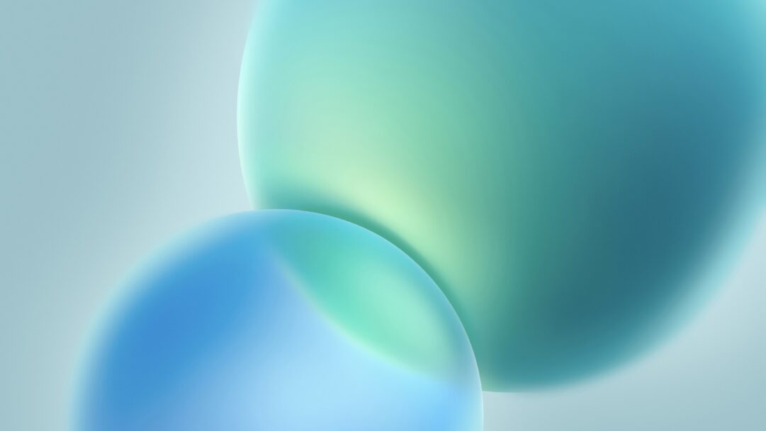 A captivating 4K wallpaper features two prominent, softly glowing abstract shapes, one predominantly blue and the other teal, interacting against a subtle light gray-blue background. The seamless gradients of blues and greens across these forms create a tranquil and modern visual experience with a soft, ethereal glow.
