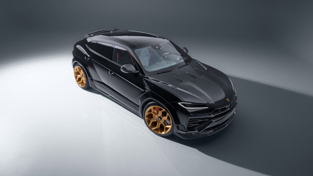 A powerful 4K wallpaper showcasing a sleek black Lamborghini Urus luxury SUV, perfectly poised in a minimalist studio setting. Its striking gold wheels dramatically contrast with the glossy black body, while professional lighting emphasizes the vehicle's sharp lines and luxurious presence.