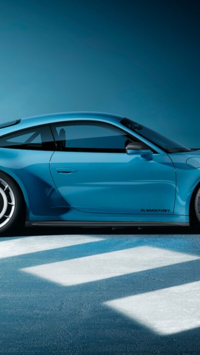 A captivating 4K wallpaper presenting a vibrant blue Porsche 911 GT3 Manthey sports car parked in profile on a textured blue-grey floor against a gradient blue background. Sharp geometric light reflections illuminate the ground beneath the car, highlighting its sleek design and the subtle Manthey branding on its carbon fiber rear wing and wheels, creating a cool, modern aesthetic.