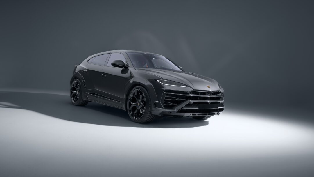 An opulent 4K wallpaper featuring a dark grey Lamborghini Urus SUV, posed in a sleek, minimalist studio environment. Dramatic lighting highlights the vehicle's aggressive front fascia and sharp contours, creating a sophisticated and powerful aesthetic.