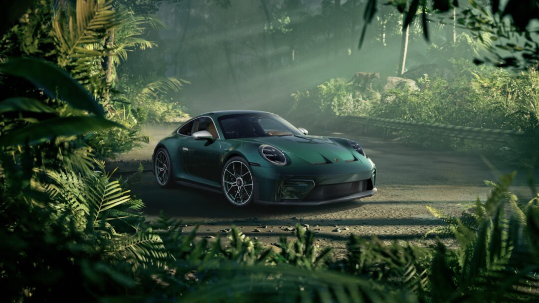 An atmospheric 4K wallpaper presents a sleek green Porsche 911 sports car parked on a dirt road within a dense, misty jungle. Sunlight beams pierce through the thick canopy and ethereal mist, illuminating the car's vibrant green finish and creating a dramatic, adventurous mood amidst the abundant tropical foliage.