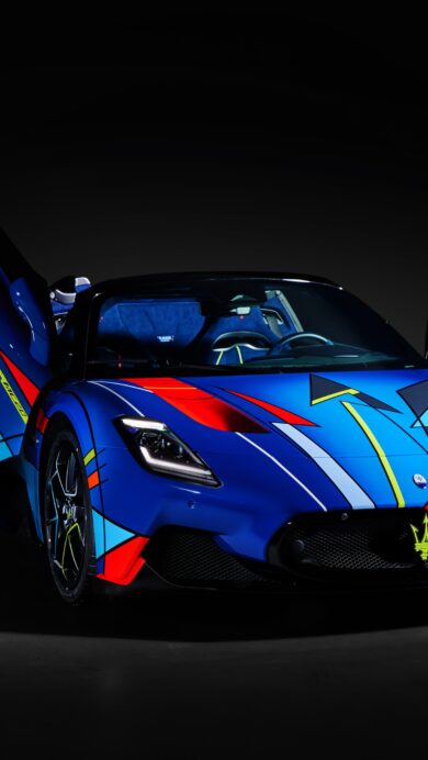 An electrifying 4K wallpaper showcasing a Maserati MC20 supercar with an abstract blue design, prominently displayed with its butterfly doors open against a dark, minimalist setting. The car's vibrant abstract livery of blue, red, yellow, and white geometric shapes creates a powerful, artistic statement, further enhanced by the dramatic lighting that emphasizes its sleek, aggressive contours.