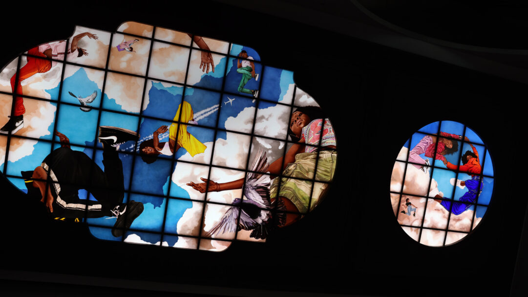 A magnificent 4K wallpaper showcasing Kehinde Wiley’s 'Go' series, transformed into an illuminated ceiling art installation within Moynihan Train Hall. Vibrant portraits of contemporary Black individuals, rendered in striking poses of ascension and repose, float amidst a celestial blue sky and billowy white clouds, creating an uplifting and majestic mood for the hall’s grand ceiling.